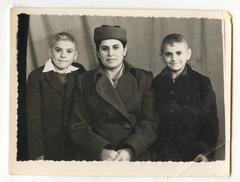 Жінка в пальто і капелюсі з дітьми
