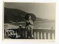 Woman with an umbrella with seaside behind