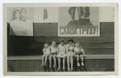 Юра, Валера, Маріана, Жоржета і Вова біля плаката "Слава труду!" (рос.)