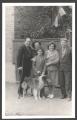 A family with a dog near the house