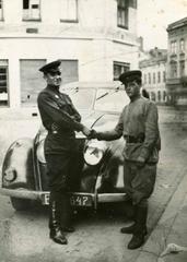 Military Men Next to a Trophy Car